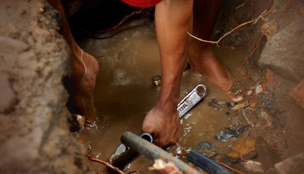 Fontanero arreglando una arqueta rota